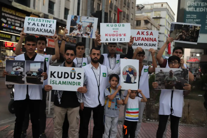 Kırmızı ışıkta pankart açarak işgalcileri protesto ettiler 